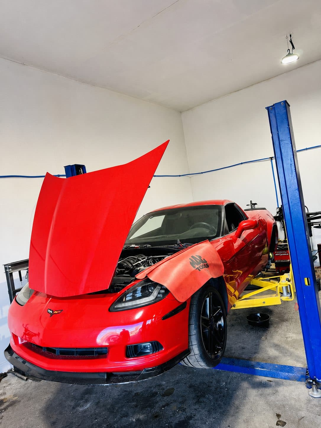 A customer vehicle up on the lift for service at Tech Bros Auto Repair